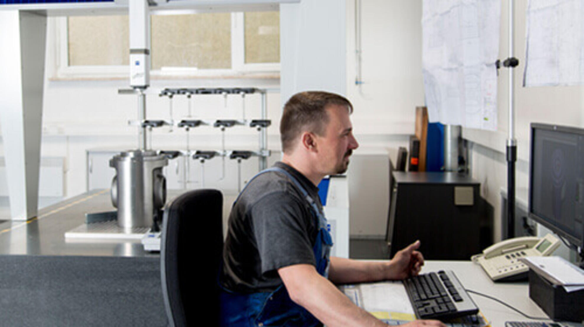 Ein Mitarbeiter sitzt an einem Computer und arbeitet mit einem Zeichenprogramm.