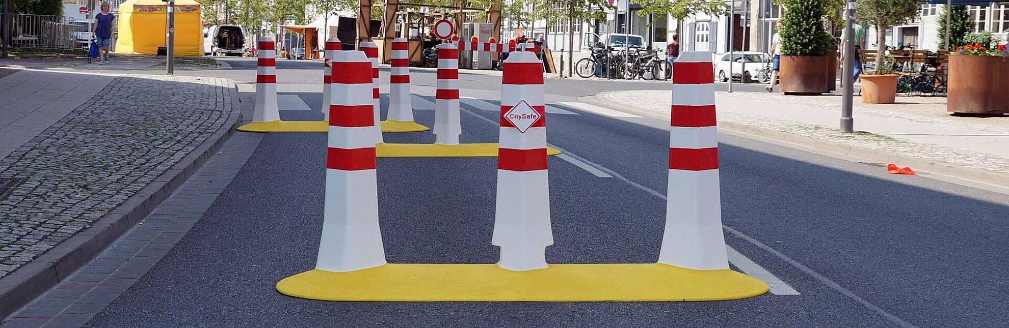 Eine Straße die mit mehreren Fahrzeug Barrieren von CitySafe abgesperrt ist.